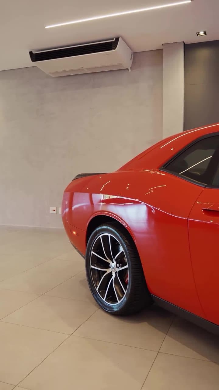 Dodge Challenger laranja no salão da Castelo Motors