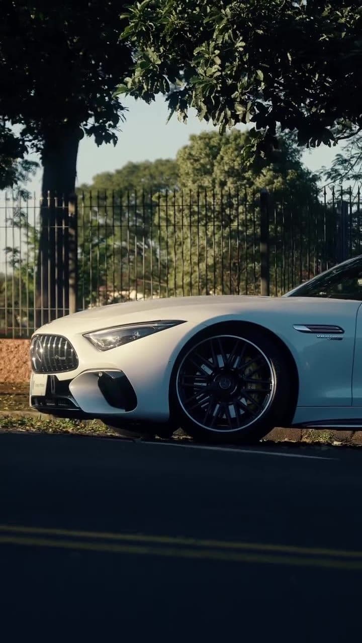 Mercedes-AMG SL 63 branca conversível numa estrada arborizada